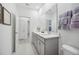 Bathroom with double sink vanity, gray cabinets, white walls and tile flooring at 1857 Columbus Path, St Cloud, FL 34771