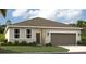 Charming single-story home featuring a two-car garage and a well-manicured front lawn at 1857 Columbus Path, St Cloud, FL 34771