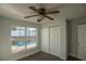 Comfortable bedroom with a fan, closet, laminate flooring, and backyard views at 1926 Binnacle St, Kissimmee, FL 34744