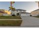 Traditional two-story home showcasing a manicured lawn, a three car garage, and mature palm trees at 1926 Binnacle St, Kissimmee, FL 34744