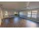 Spacious living room featuring wood-look flooring, neutral paint, and a decorative glass front door at 1926 Binnacle St, Kissimmee, FL 34744