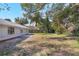 View of the home's backyard and exterior featuring mature trees at 1995 Brewster Dr, Deltona, FL 32738