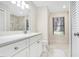 Bathroom with white cabinets, quartz counters, a large mirror, and a step-in shower with marble tile at 1995 Brewster Dr, Deltona, FL 32738