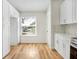 Well-lit kitchen featuring white cabinets, a modern sink, and sleek wood flooring at 1995 Brewster Dr, Deltona, FL 32738