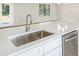 Bright kitchen boasts stainless sink, faucet, and appliances with white cabinets and stunning quartz counters at 1995 Brewster Dr, Deltona, FL 32738