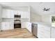 Stylish kitchen showcasing stainless steel appliances, white cabinetry, and wood floors at 1995 Brewster Dr, Deltona, FL 32738