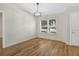 Bright room features light wood floors, white walls, a modern chandelier and a large window at 1995 Brewster Dr, Deltona, FL 32738