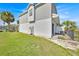 Exterior side view of home, featuring a lawn, palm trees, and fence at 2001 Claudia Ln # 2001, Kissimmee, FL 34741