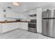 Bright kitchen with white cabinets, stainless steel appliances, and sleek marble-patterned flooring at 2121 Woodland Dr, Apopka, FL 32703