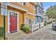 Stylish townhouse features a vibrant red door, white trim, and manicured landscaping for a welcoming appeal at 2280 San Vital Dr # 108, Kissimmee, FL 34741