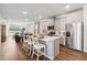 A kitchen and living room combination highlighting stainless steel appliances, gray cabinets, and counter seating at 2567 Kinsale Ln, Ormond Beach, FL 32174