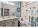 Well-lit bathroom features a single sink vanity, a large mirror, and a shower-tub combo with a stylish curtain at 2606 Pinyonpine Ln, Sanford, FL 32773