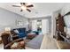 Bright living room features wood floors, plush blue sofa, leather armchair, and sliding glass doors to the outdoor patio at 2606 Pinyonpine Ln, Sanford, FL 32773