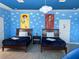 Bright 'Toy Story' themed bedroom features two twin beds, playful wall decor, and a whimsical cloud light fixture at 2800 Simile St, Kissimmee, FL 34746