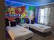 Bright bedroom featuring two beds, a themed mural, and stylish decor with Mickey Mouse accents at 2800 Simile St, Kissimmee, FL 34746