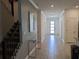 Entryway featuring tiled floors, stairs, and a view of the front door at 2800 Simile St, Kissimmee, FL 34746