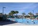 Community swimming pool featuring palm trees, lounge chairs, cabanas, and many people swimming at 2800 Simile St, Kissimmee, FL 34746