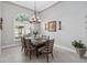 Dining room with modern chandelier, arched window, seating for six, and neutral colors at 2929 University Acres Dr, Orlando, FL 32817