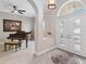 Inviting foyer with a piano, neutral paint and flooring and lots of natural light at 2929 University Acres Dr, Orlando, FL 32817