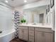 Well-lit bathroom featuring double sink vanity, and a tub with a decorative shower curtain at 2956 Oak Park Way # 45, Orlando, FL 32822