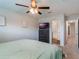 Spacious bedroom with a queen-sized bed, ceiling fan, dresser with a TV, and doorway that leads to a bathroom at 2956 Oak Park Way # 45, Orlando, FL 32822