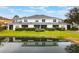 Back exterior view of modern townhomes, showing backyard and a pond at 2956 Oak Park Way # 45, Orlando, FL 32822