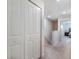 Hallway features a closet and doorway that show the main bedroom with a queen bed, side tables, and lamps at 2956 Oak Park Way # 45, Orlando, FL 32822