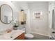 Bright bathroom featuring a tub with shower, white cabinets, and a stylish gold framed mirror at 2976 Saint George St, Orlando, FL 32814