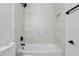 The renovated bathroom features a bathtub with a marble-look tile surround at 311 Sandlewood Trl # 4, Winter Park, FL 32789