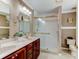 Bathroom featuring double sinks, a glass enclosed shower, and updated fixtures at 3668 Peppervine Dr, Orlando, FL 32828