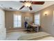 Well-lit bedroom featuring a ceiling fan, neutral tones, and a built-in desk with plantation shutters at 3668 Peppervine Dr, Orlando, FL 32828