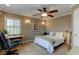 Bright bedroom with a modern ceiling fan, desk, and natural light streaming through the window at 3668 Peppervine Dr, Orlando, FL 32828