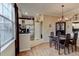 Cozy dining area featuring a classic chandelier, wood floors, and an adjacent kitchen at 3668 Peppervine Dr, Orlando, FL 32828