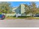 Exterior view of the townhome featuring a fenced-in patio area, lush landscaping, and ample parking at 3668 Peppervine Dr, Orlando, FL 32828