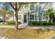 Two-story townhome featuring an oval window accent, lush landscaping, and a tree-lined walkway at 3668 Peppervine Dr, Orlando, FL 32828