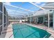 Screened-in pool and spa with blue-tiled accents, surrounded by a spacious deck and covered patio at 38 Lakeview Reserve Blvd, Winter Garden, FL 34787