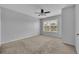 Carpeted bedroom featuring neutral walls, ceiling fan and a window with neighborhood view at 4004 San Gallo Dr # 107, Kissimmee, FL 34741