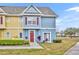 Beautiful two-story townhome with a blue exterior and landscaping on a sunny day at 4012 Santa Maria Dr # 102, Kissimmee, FL 34741