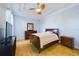 Cozy bedroom featuring hardwood floors, ceiling fan, and dresser, with neutral color palette at 4464 Cleary Way, Orlando, FL 32828