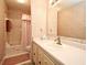 Bathroom with a sink, a large mirror, floral wallpaper and a shower and tub with a pink shower curtain at 536 Orange Dr # 16, Altamonte Springs, FL 32701