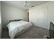 A minimalist bedroom with a ceiling fan, carpet, and a neatly made bed with white bedding and gray pillows at 5752 Iron Brand Rd, St Cloud, FL 34771