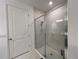 Modern bathroom featuring a glass enclosed tiled shower with silver fixtures and white marble-style tile at 5752 Iron Brand Rd, St Cloud, FL 34771