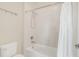 This bathroom features a clean white bathtub and shower combination with a matching white shower curtain and toilet at 5774 Fulham Pl, Sanford, FL 32771