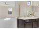 This bathroom features a well-lit vanity with modern fixtures and a view into an adjacent bedroom through an open doorway at 5774 Fulham Pl, Sanford, FL 32771