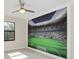 This bedroom features a ceiling fan and a large stadium mural that provides a unique and playful touch to the space at 5774 Fulham Pl, Sanford, FL 32771