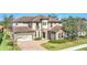 Elegant two-story home featuring a tile roof, stone accents, a three-car garage and a charming balcony at 5774 Fulham Pl, Sanford, FL 32771
