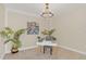 Bright home office with a simple desk, modern chair, and a decorative chandelier fixture at 5774 Fulham Pl, Sanford, FL 32771