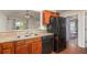 Eat-in kitchen with stainless steel sink, wood cabinets and black appliances at 610 Carolina Ave, St Cloud, FL 34769