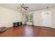 Bright living room boasts wood floors, ceiling fan, and a view of the front door at 610 Carolina Ave, St Cloud, FL 34769