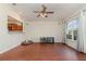 A spacious living room with ceiling fan, wood floors, and a view of the kitchen at 610 Carolina Ave, St Cloud, FL 34769